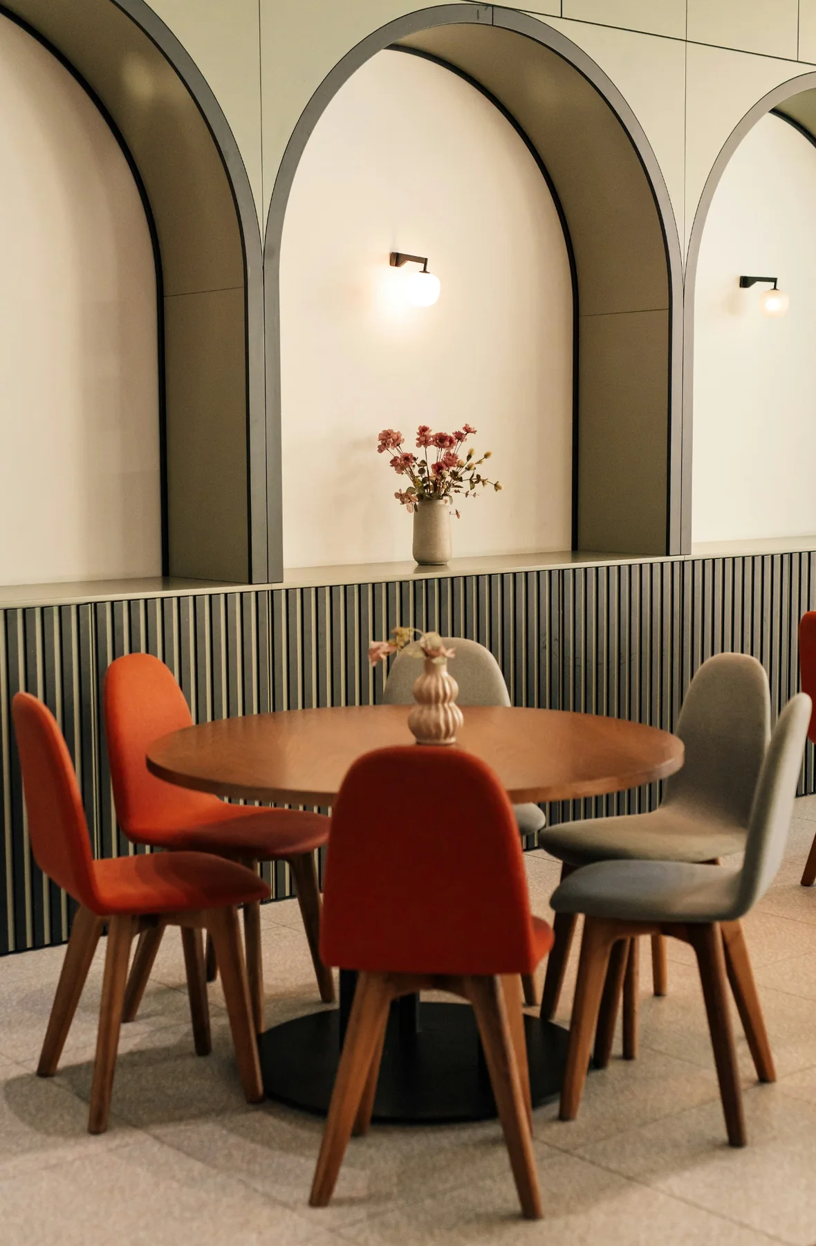 Restaurant dining space with curved arches and warm-toned seating